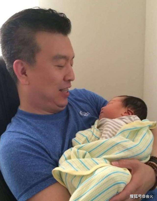 照片中张泽群怀抱着婴儿，满脸幸福的看着他，隔着屏幕可以感受到他的喜悦。