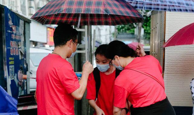 武汉家长暴雨中送考画面令人泪目口罩旗袍天团亮相为孩子加油