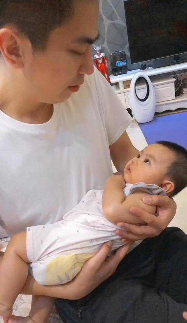 爸爸强硬“命令”宝宝睡觉，宝宝趴爸爸怀里假睡，大眼睛滴溜溜乱转笑翻妈妈