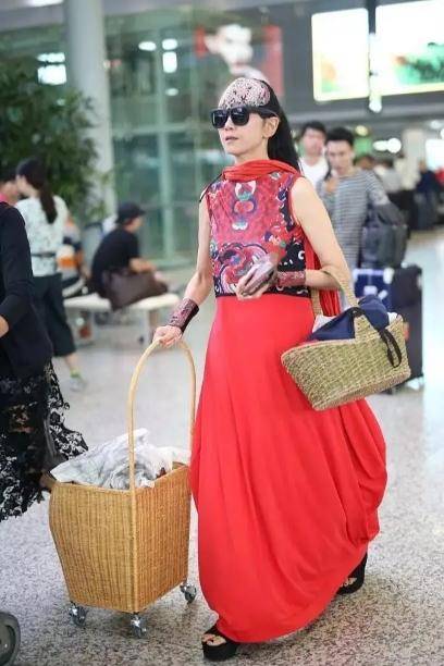 竹筐|60多岁的杨丽萍活出了自信，穿红色民族裙走机场，手推竹筐好洋气