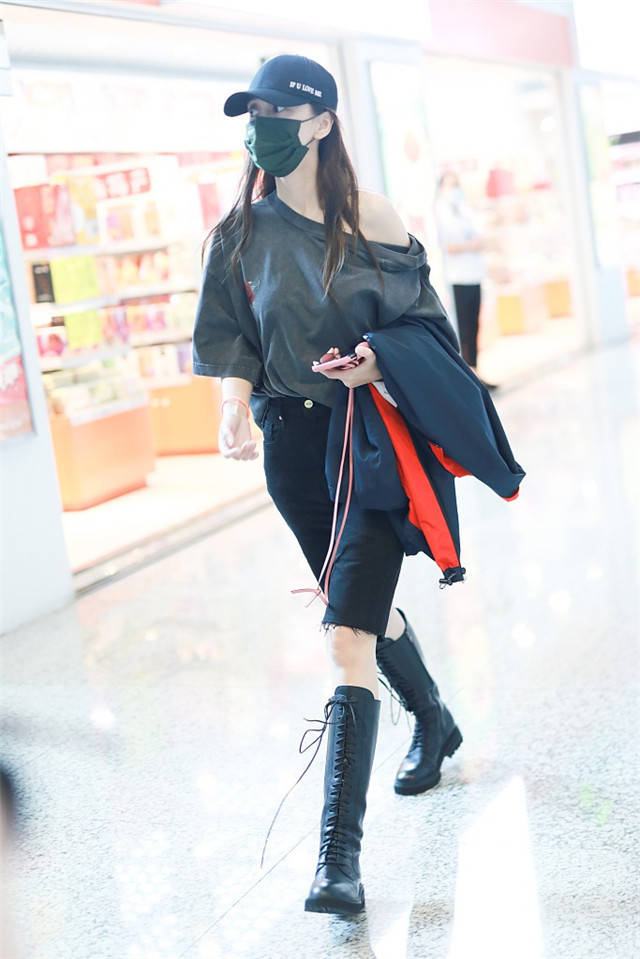 Baby现身机场穿宽松T恤秀香肩,长靴美腿抢镜
