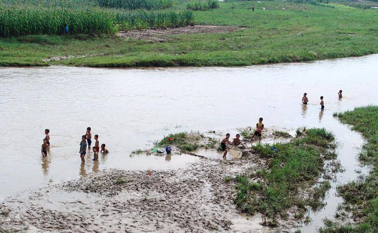 朝鲜农村的小孩,放暑假以后,在河边玩耍,捉鱼.无忧无路,非常快乐.