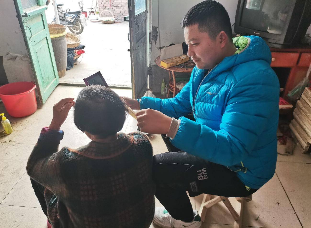 图为志愿者帮助老人梳头,还与老人聊天.