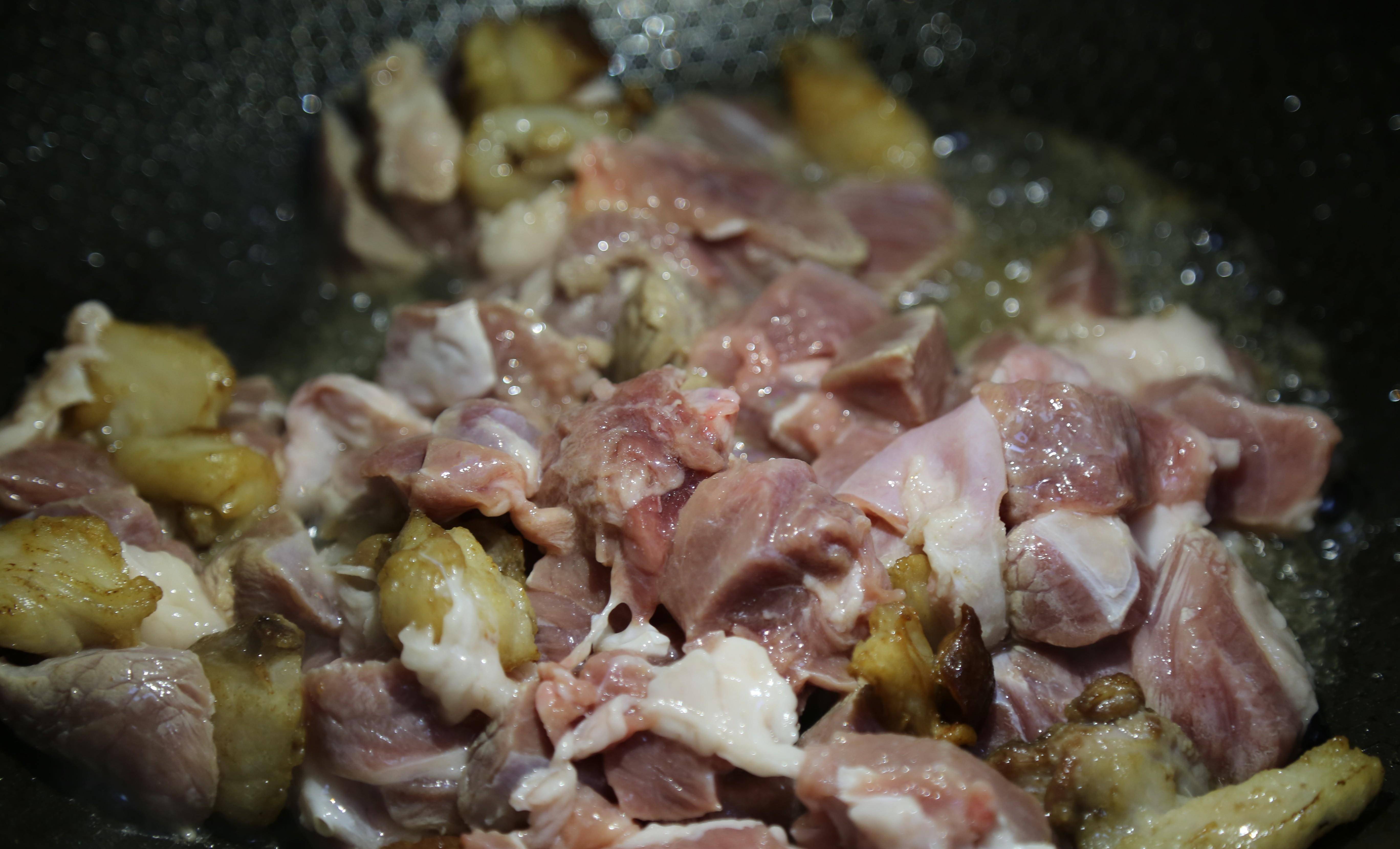 4,待肥肉油脂炒出,颜色变得有些微黄时放入剩余的羊腿肉一起煸炒.