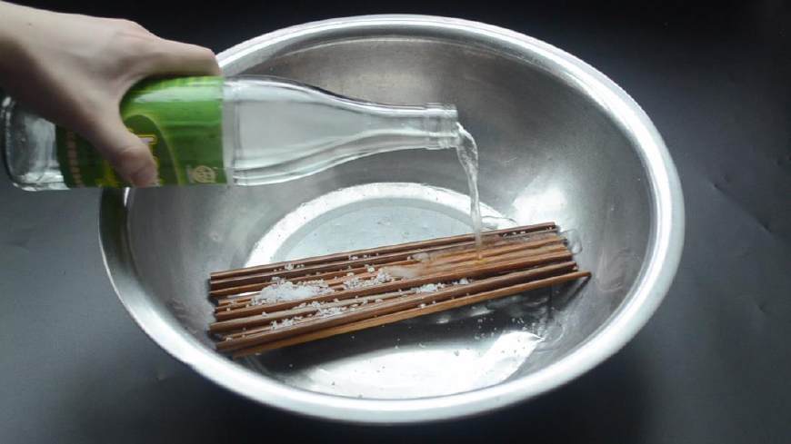首先把新买的筷子拆开放进盆子里,并且往筷子上倒点食用盐