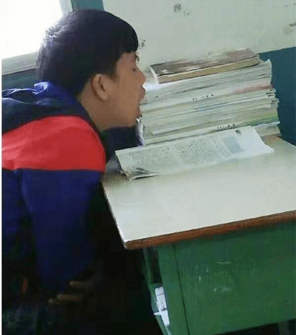 搞笑图片:这位男同学的睡姿很奇葩,仿佛要把知识"吃"肚子里.