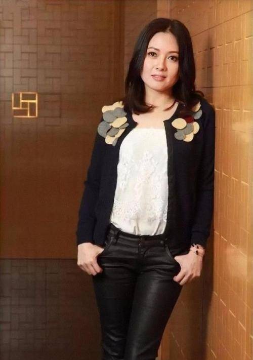 李丽珍穿了一件白色圆领t恤搭配黑色皮裤,外面加了一件黑色西装外套