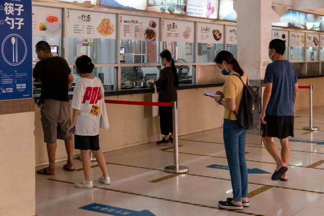排队打饭自觉隔开安全距离遵照规定有序就餐饭堂里虽少了往日的喧闹