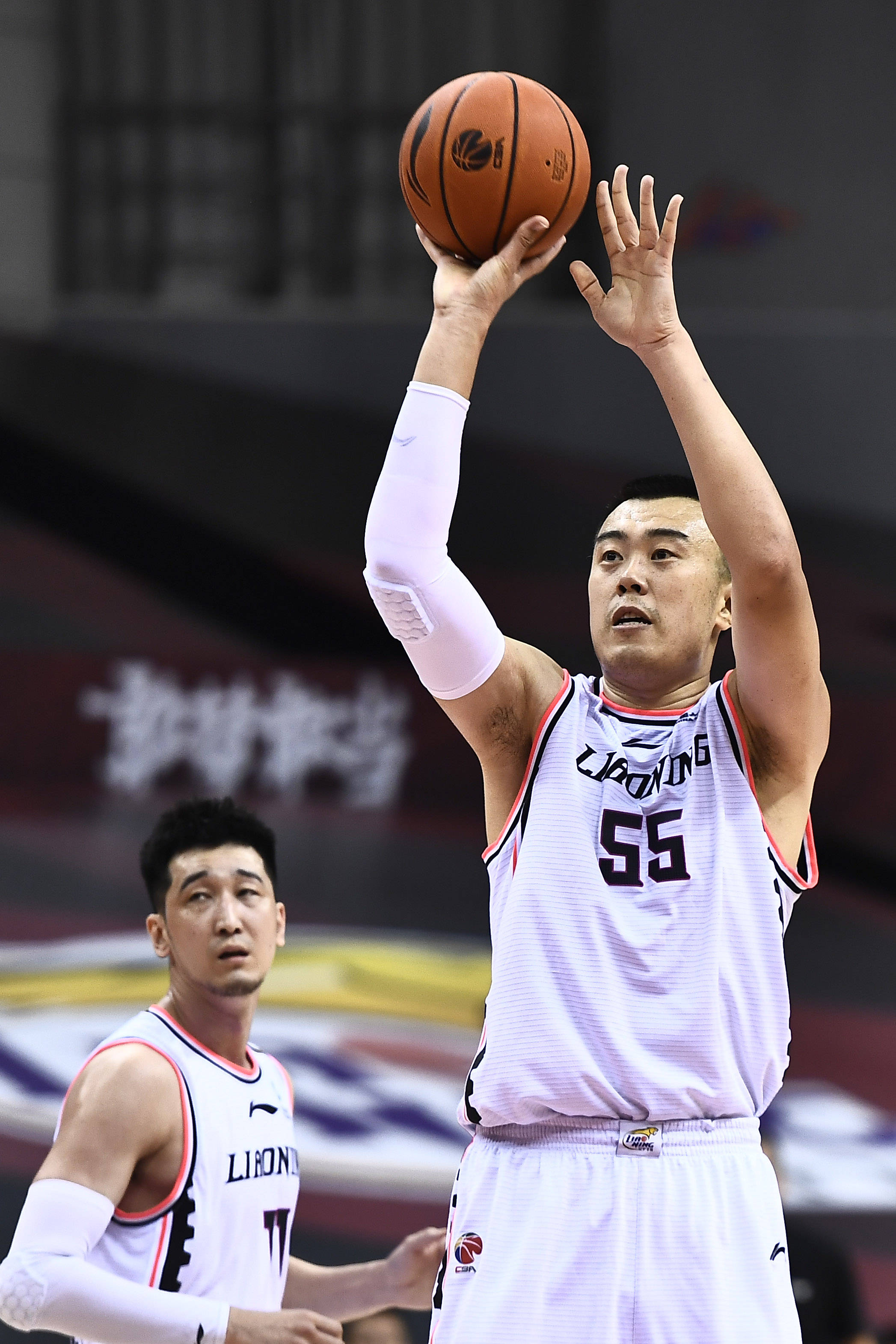 7月17日,辽宁本钢队球员韩德君(右)在比赛中投篮.
