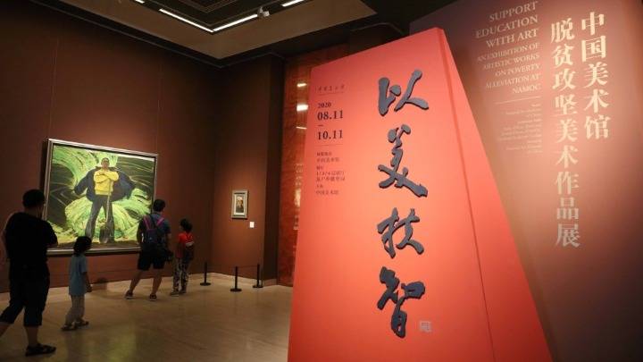 观众在"以美扶智——中国美术馆脱贫攻坚美术作品展"上欣赏展品