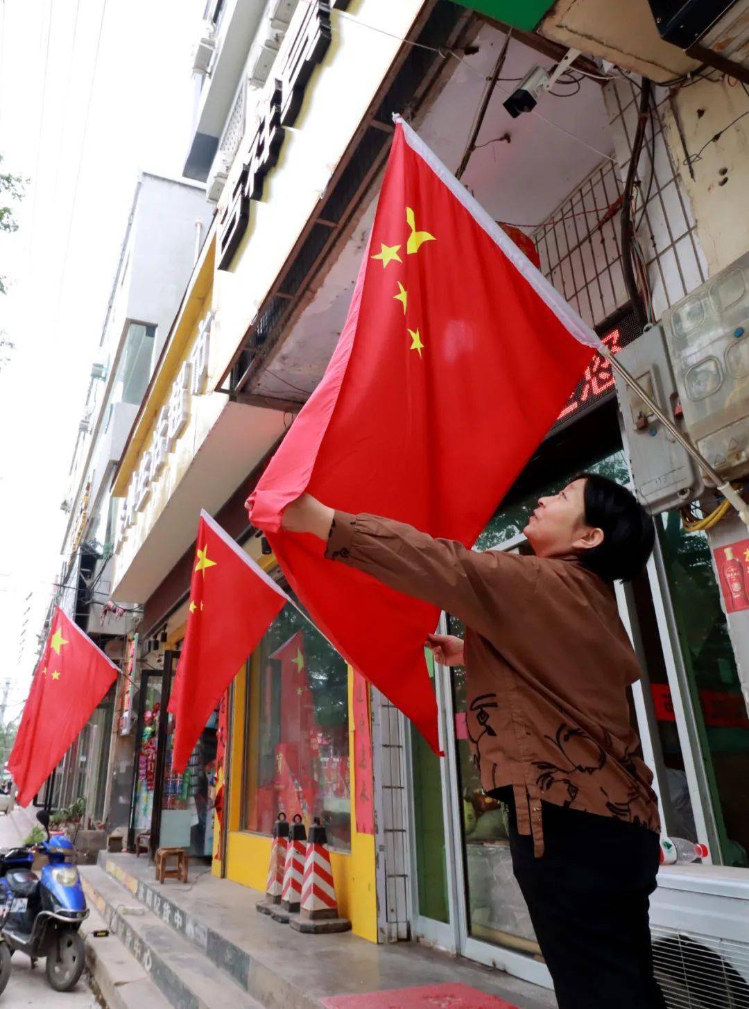 挂国旗迎国庆 街头洋溢"中国红"