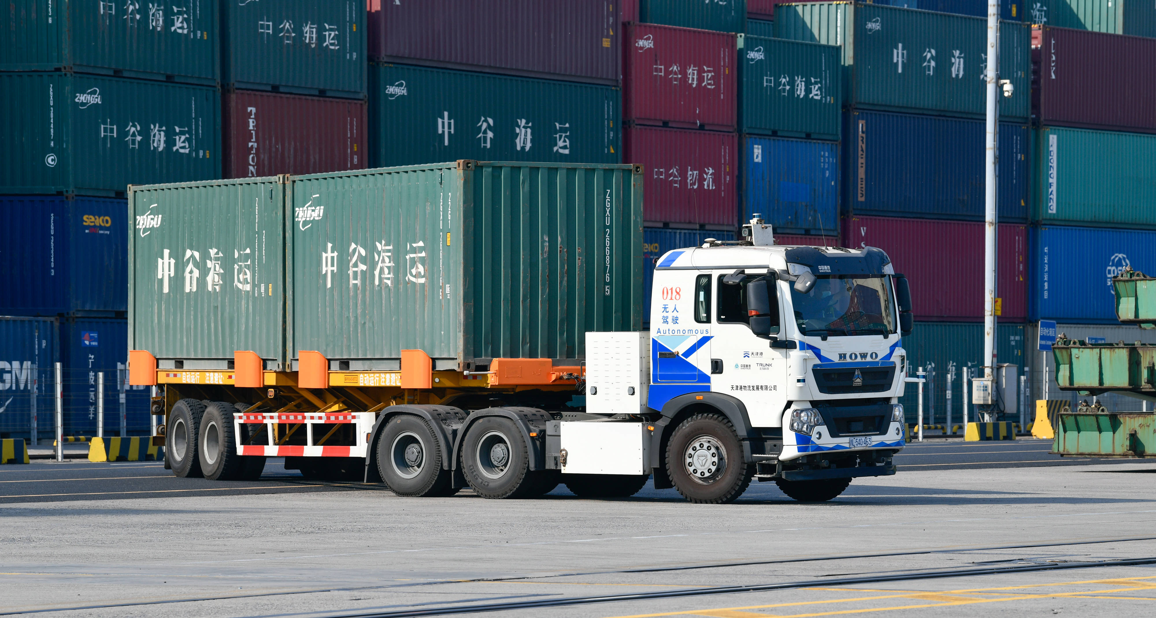 无人驾驶电动卡车装载着集装箱行驶在天津港东突堤码头(11月4日摄).
