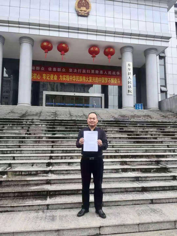 刑讯逼供案受害人李金奎手持一审判决书,称"这一刻他和弟弟已等待了19