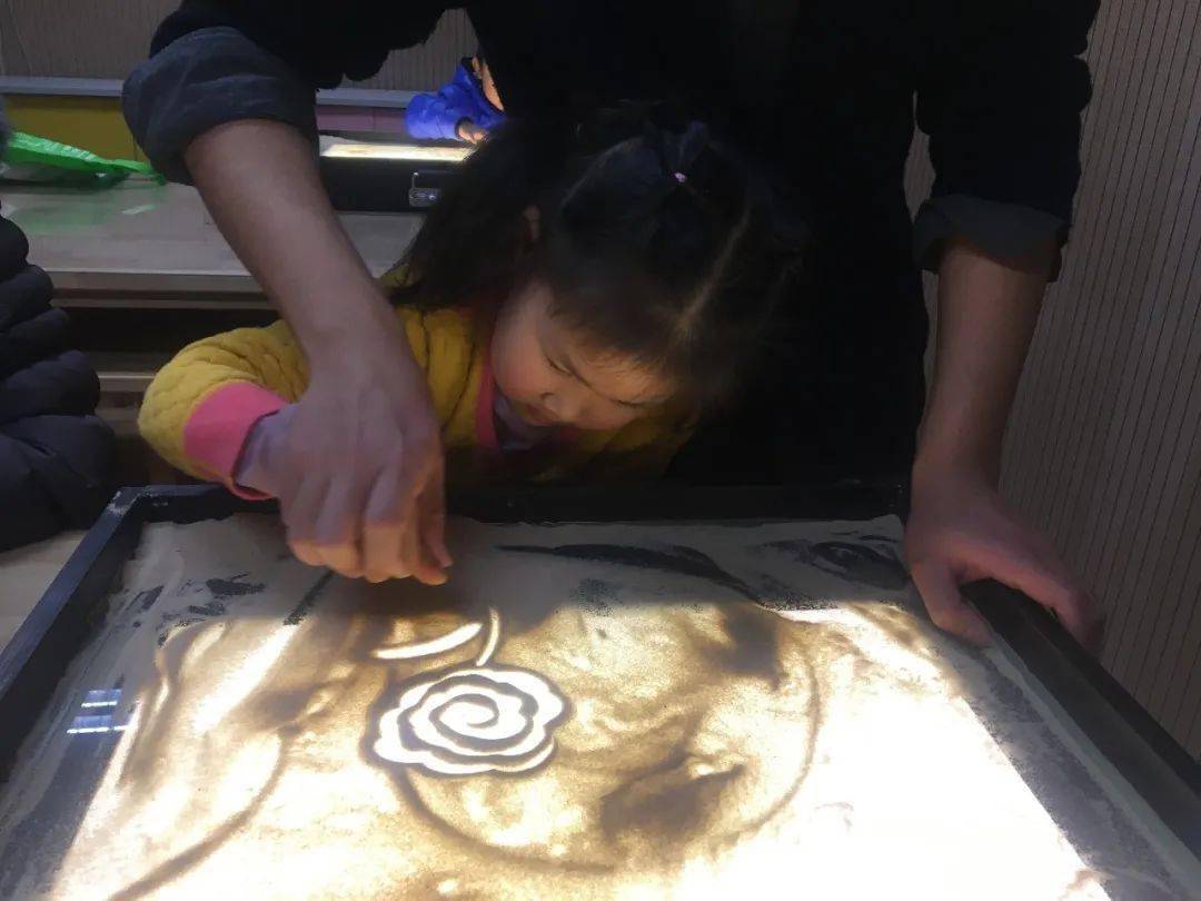 沙画制作完成,小朋友们看着漂亮的沙画作品,脸上洋溢着满满的成就感