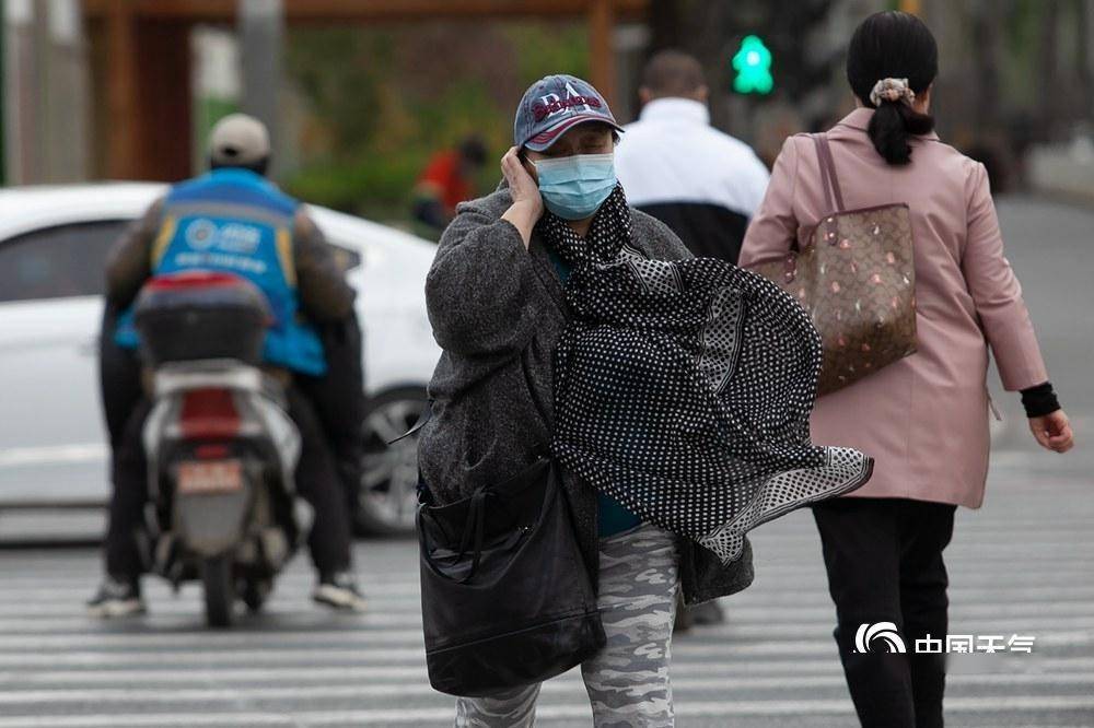 北京冷风呼呼吹 街头行人厚装出行泥点车排长队