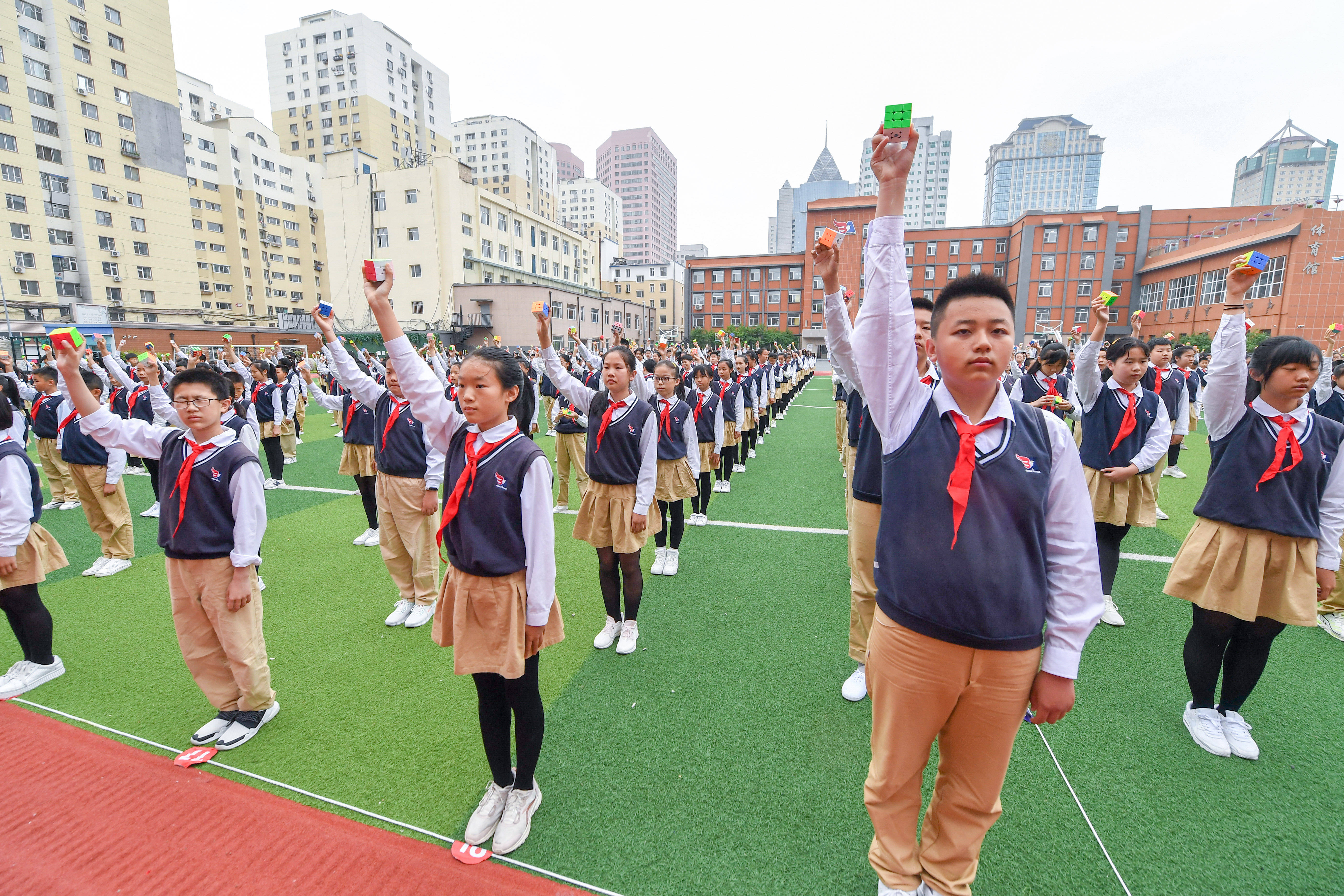 6月10日,在北安小学操场,成功还原魔方的学生高举魔方.