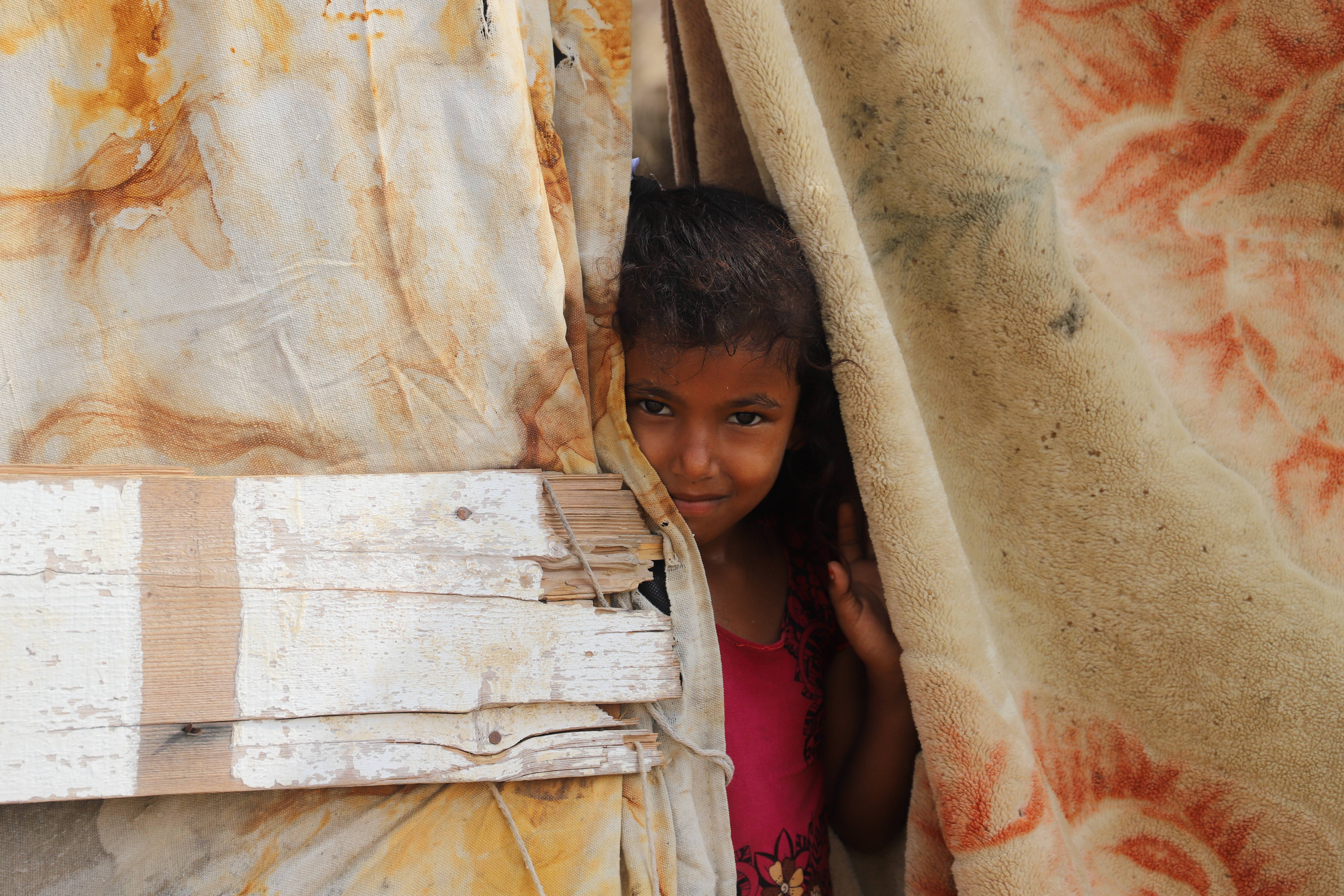 6月17日,一名儿童站在也门北部哈杰省一座难民营内.