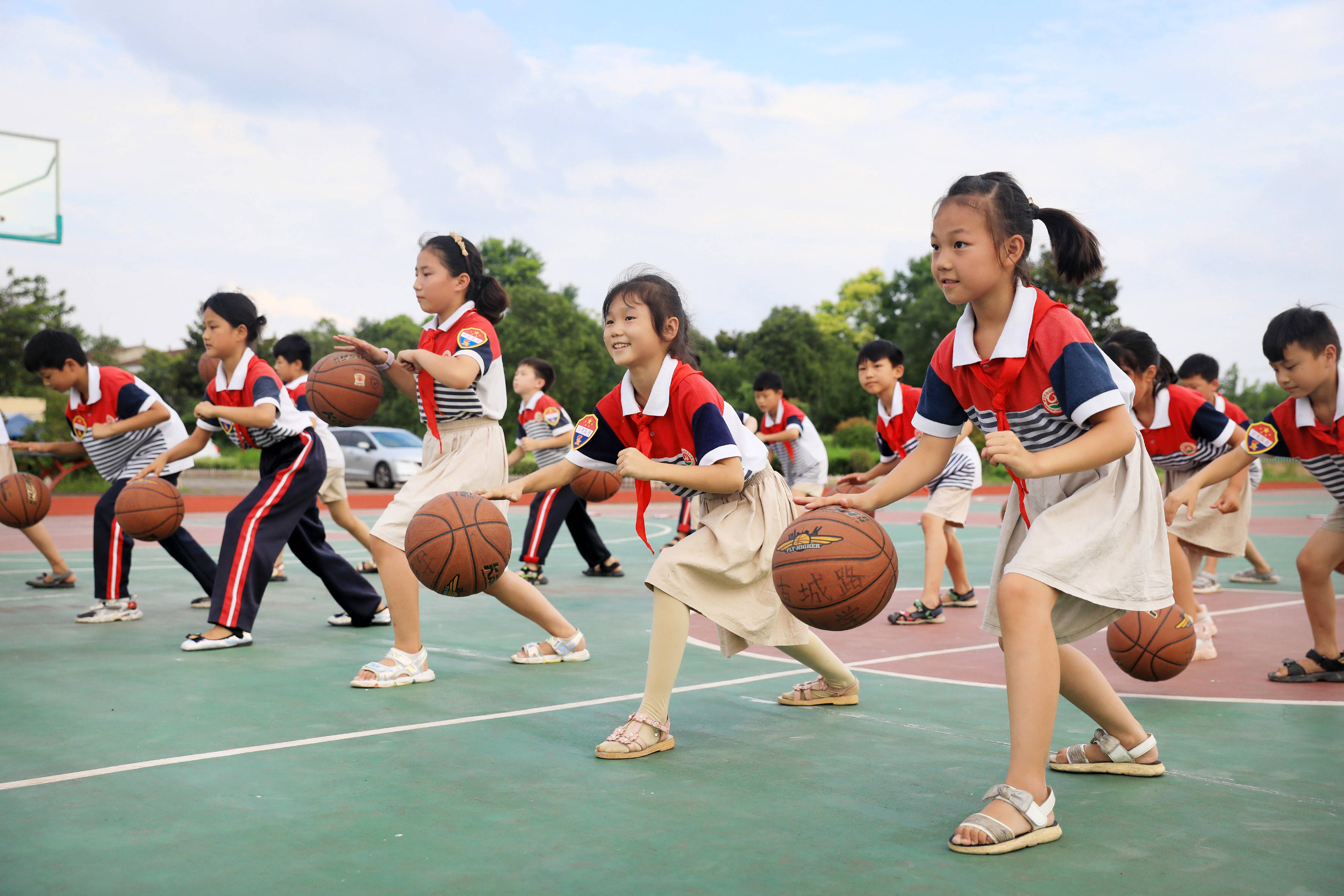 7月22日,在淮北市相山区郭王小学,学生们在练习篮球.