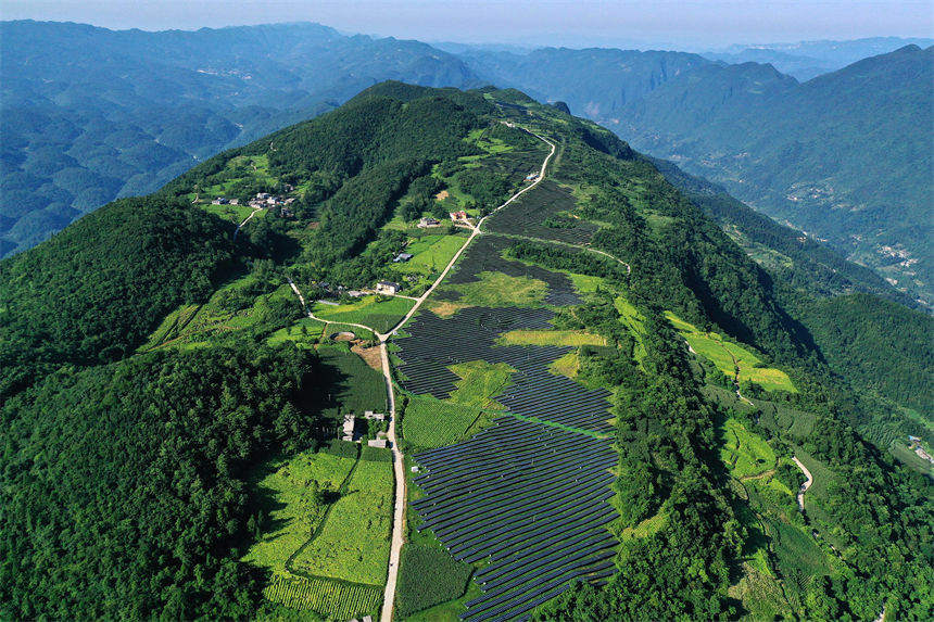 重庆市黔江区麒麟盖山地光伏发电板与群山,民居,农田相掩映,美如画卷.