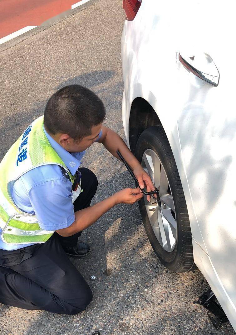 半路爆胎—女司机焦急不已 帮忙换胎—协警烈日下助民