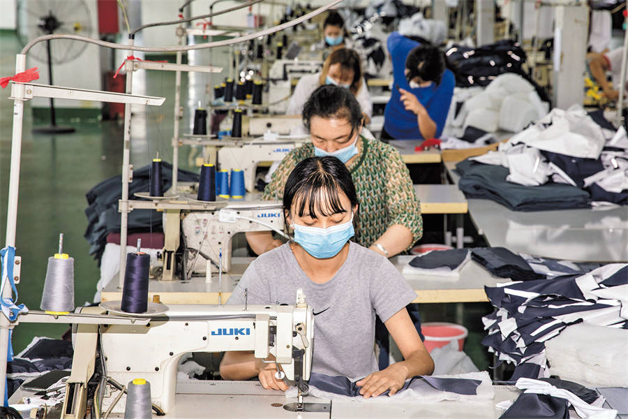 3日,精河县维郎工业有限责任公司加工车间内,员工缝制服装.
