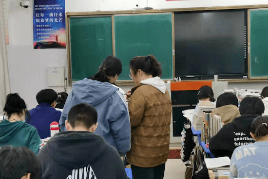 晓晓就站在教室门口,迎接上课的同学们,不时地提醒着学生注意疫情防控