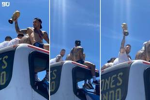 梅西在游行大巴上高举大力神杯，一道光束将他笼罩