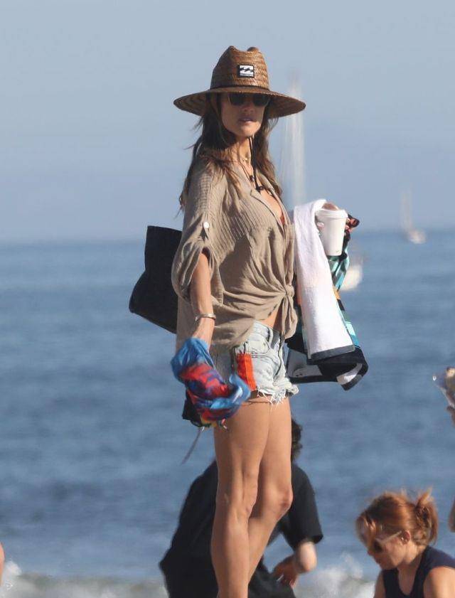 亚历山大·安布罗休穿飘逸开衫搭牛仔热裤,在海边踏浪,像拍大片