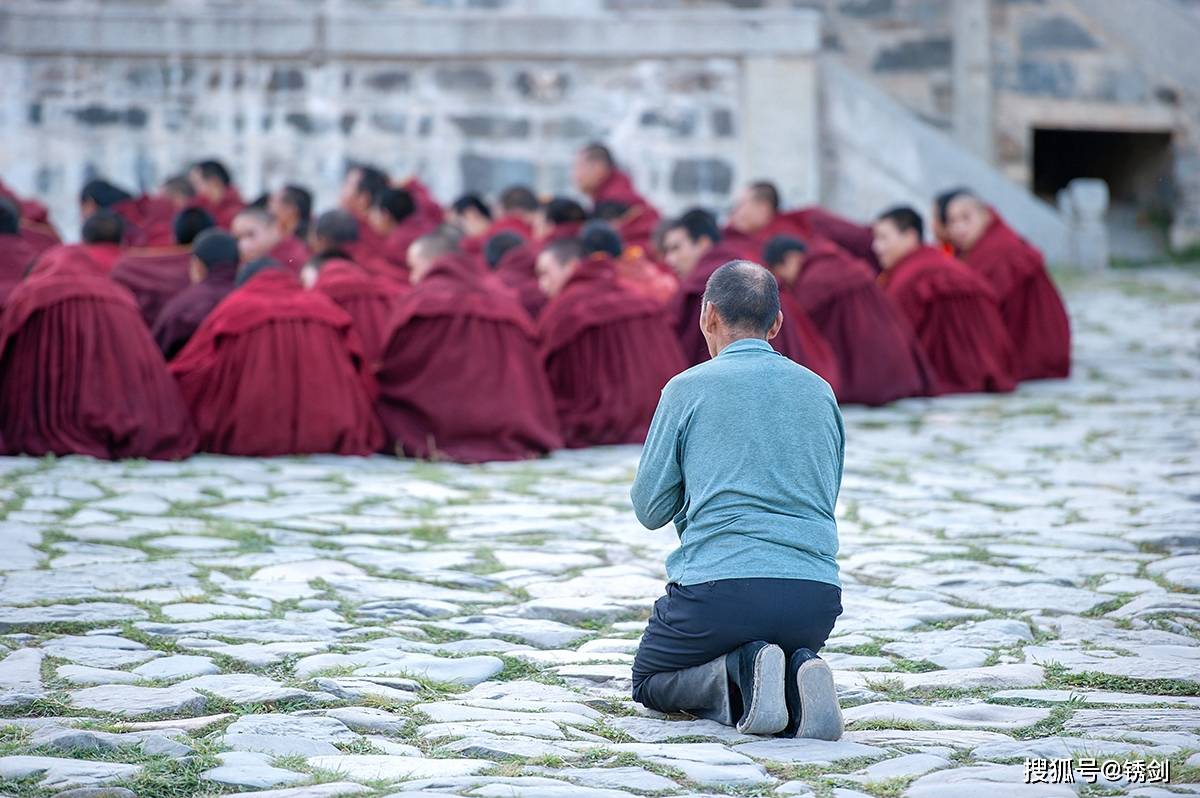 一旁的藏族信众,虔诚地跪拜在地