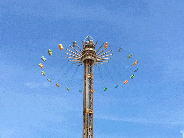 在数十米的高空,秋千缓缓沿着中轴线旋转上升,悬挂的平面一圈圈飞速