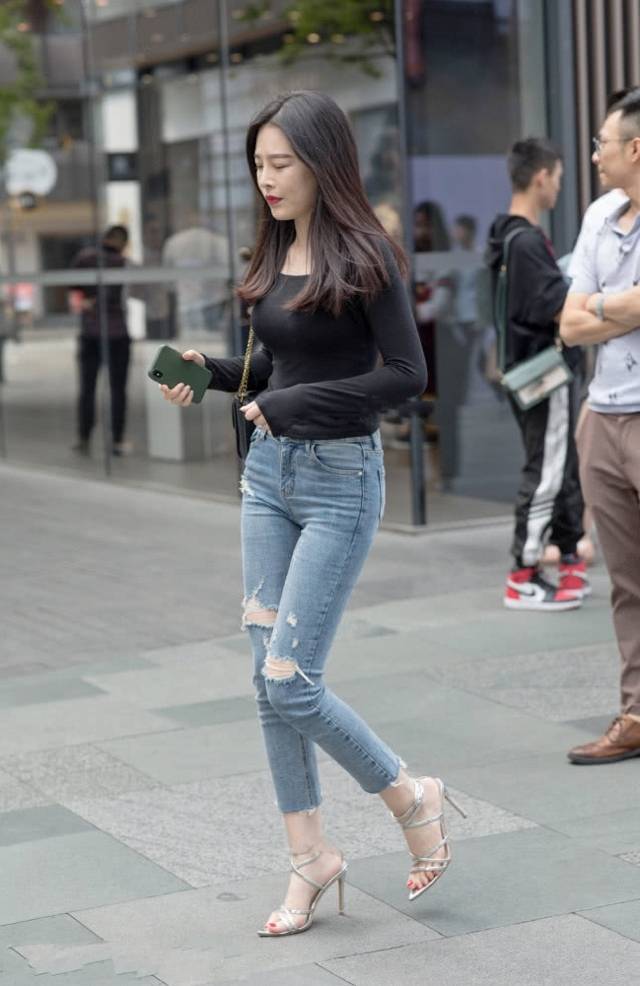 路人街拍,美女搭配黑色的修身打底衫,更显自信优雅