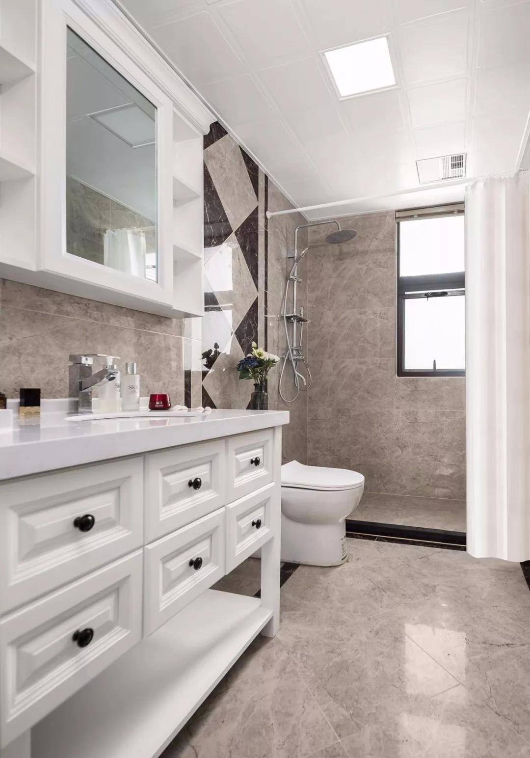 卫生间整体通铺现代感的咖啡色瓷砖,搭配白色成品台盆柜与镜柜