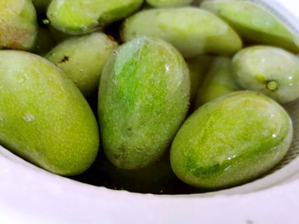 〈具体做法〉 土芒果采摘后先洗刷刷表面的尘土.泡在水里.