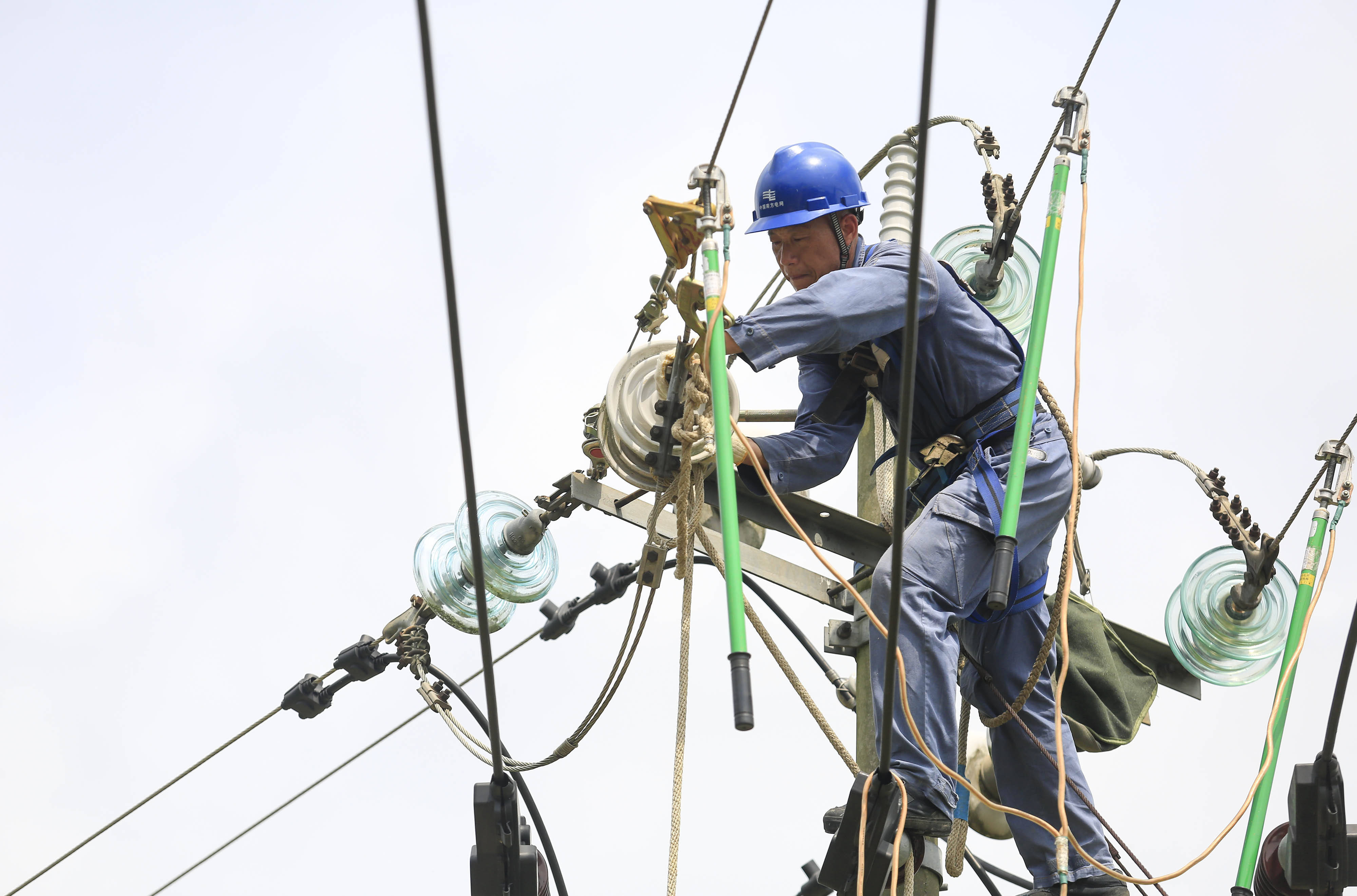 在柳城县大埔镇三塘村,一名电力工人在空中作业.