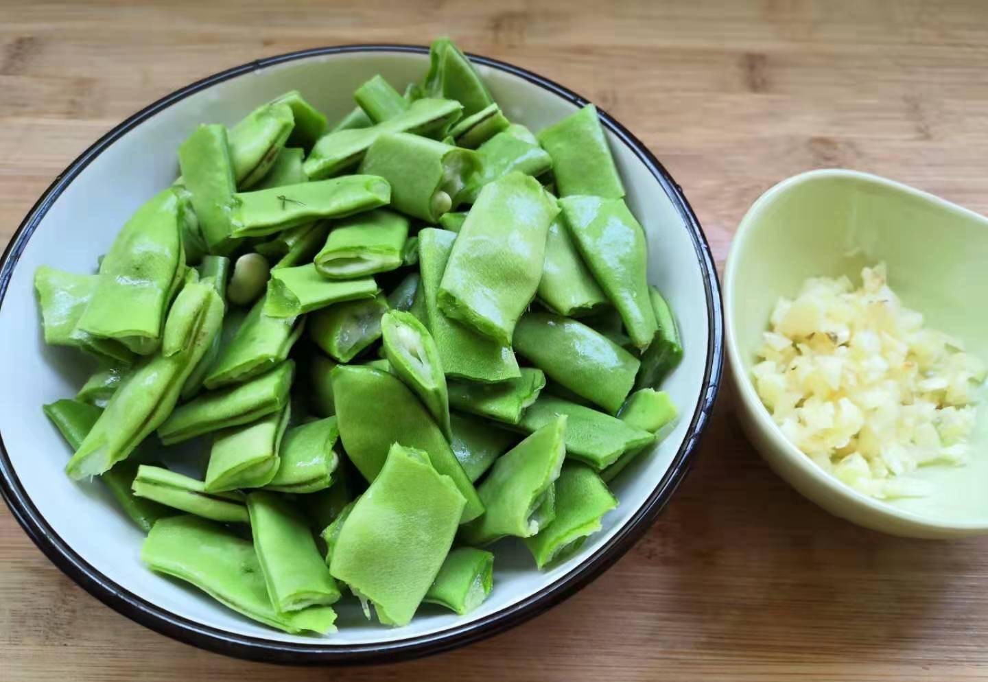 3,刀豆角洗净掰成段,蒜粒切末.