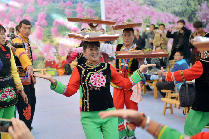 南涧跳菜头手嘴全用来抬菜跳着舞蹈耍着杂技把菜上