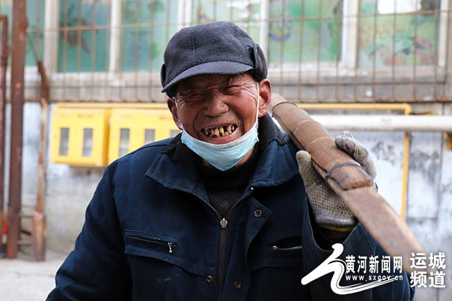 寒冬室外温度零下七度,在运城市某小区门口,身着旧棉衣,头戴一顶毡帽