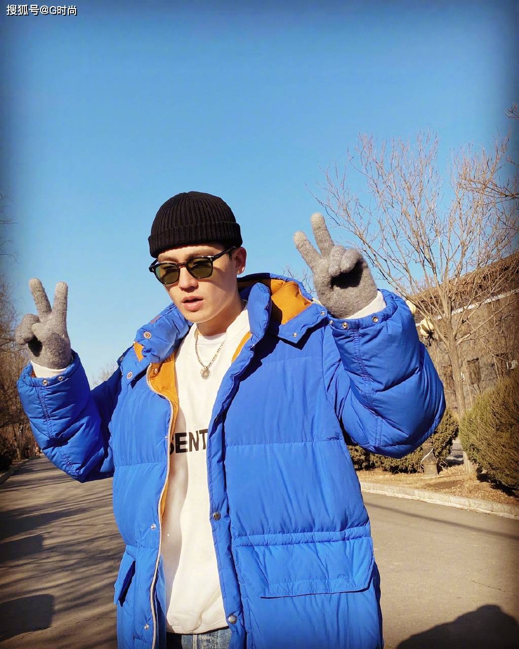 身着蓝色羽绒服搭休闲牛仔,墨镜装扮潮范儿十足,get欧豪同款游客照吧