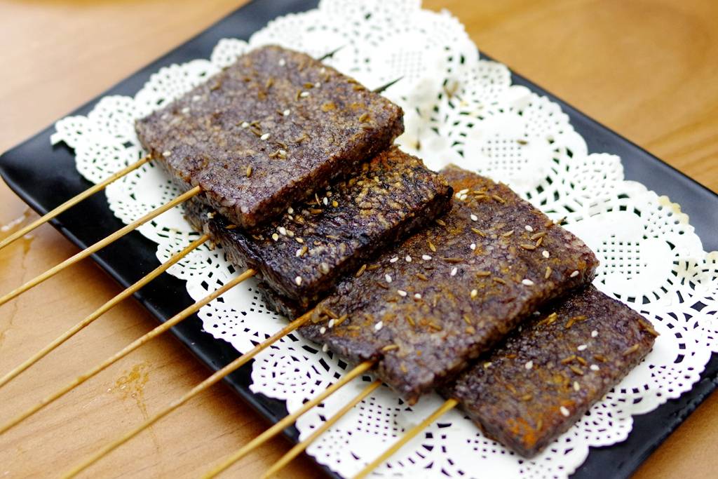 或许描述成泡透猪血的米饭做成的年糕大家比较好理解,这东西烤出来后