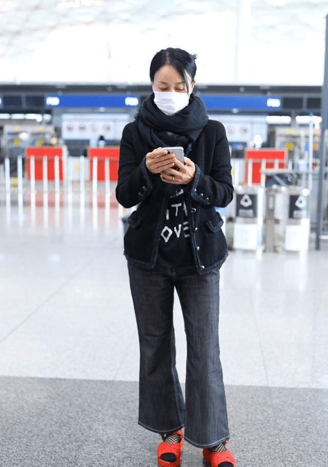 那英真怕冷,裹着围巾走机场,下搭一条喇叭裤气场全穿出来了!