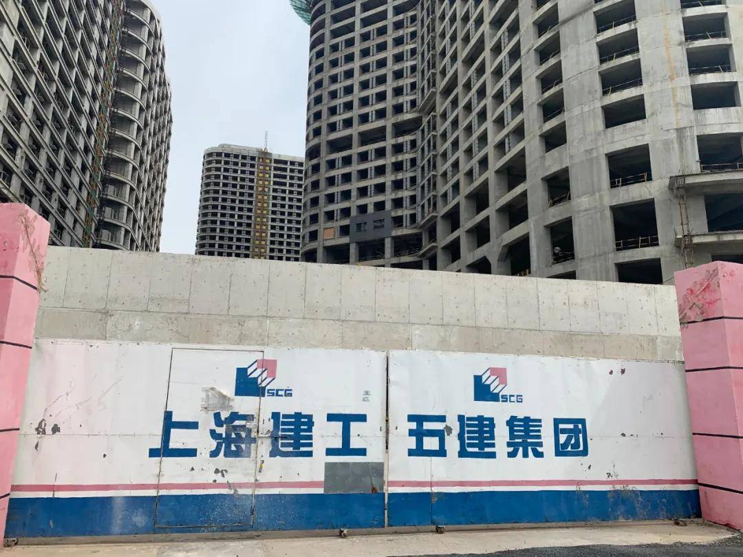 就到达了工地的大门口,门上是施工方上海建工集团的标志,大门紧闭,没