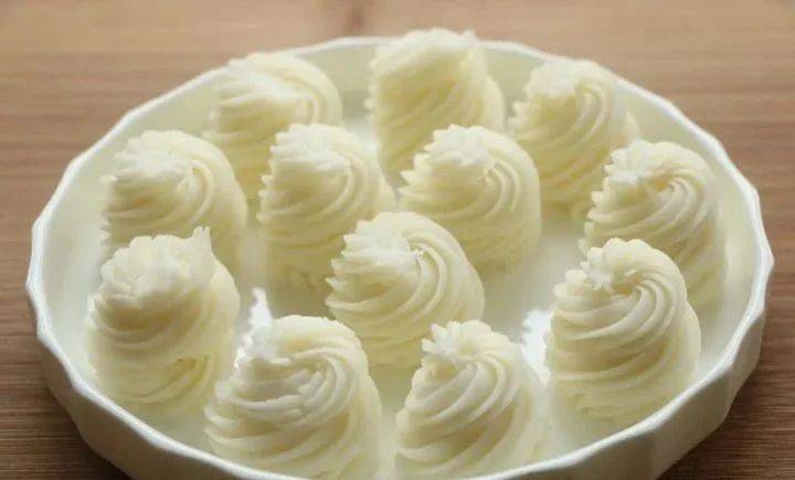 将制作好的山药泥与牛奶和炼乳一起混合,充分搅匀,放入裱花袋中,在盘