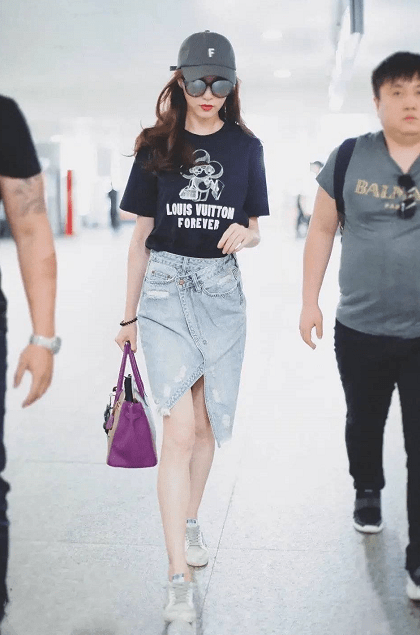 青春|唐嫣当妈后更会打扮，穿错位式半裙走机场，新潮减龄美成小姑娘！