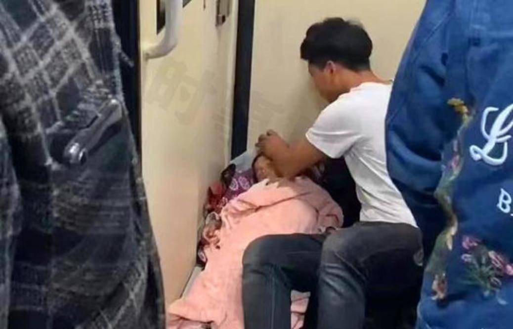 浙江一男子带女儿坐火车，在过道用衣服搭建小床，生活不尽人意