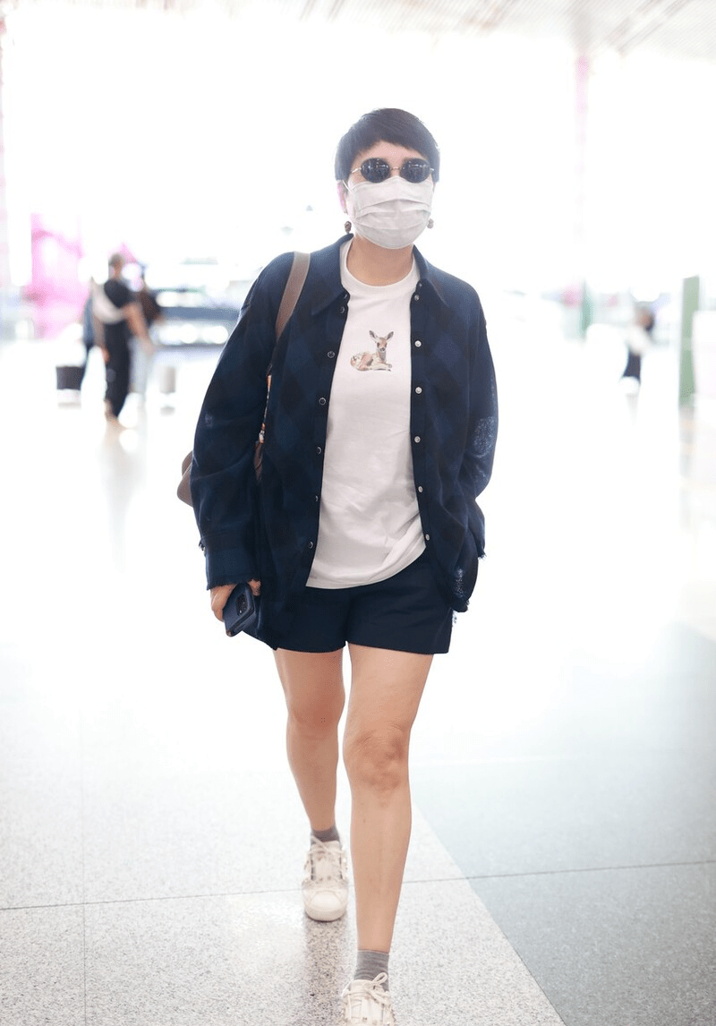 黑色|张凯丽58岁又怎样？穿衬衫配短裤走机场，“豆腐腿”哪像奶奶辈