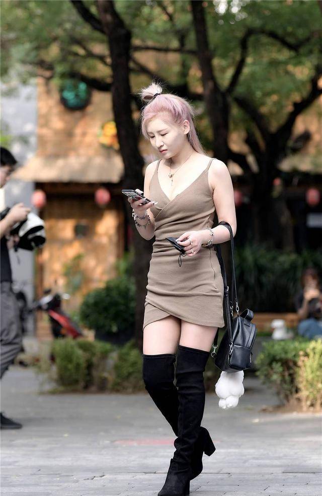 街拍小姐姐吊带紧身连衣裙搭过膝长靴渲染的发型高挑又迷人
