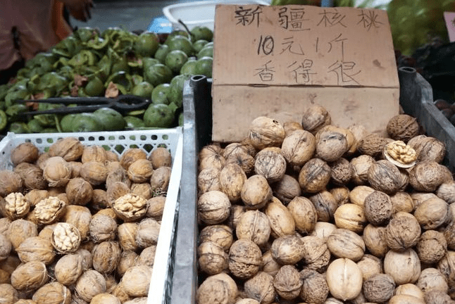摊贩核桃摊被城管踢翻?城管:是摊贩打我们,我们在控制他