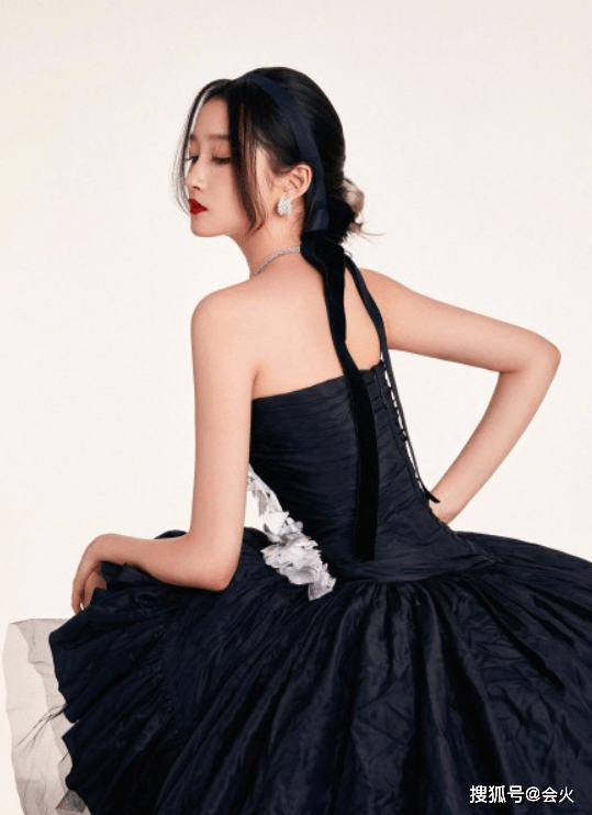 显得关晓彤出席活动，穿抹胸短裙配黑丝大秀身材，脚踩细高跟走路不稳