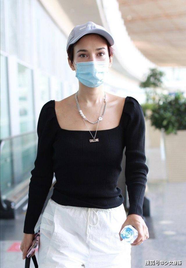 显得 卢靖姗走机场真放得开，方领针织衫硬拽成一字肩，意外时髦洋气