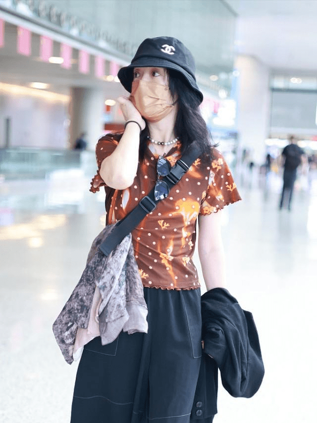 个性 周迅走机场挺“张扬”，穿棕色星空小半袖，脚上穿的粉袜子更抢镜